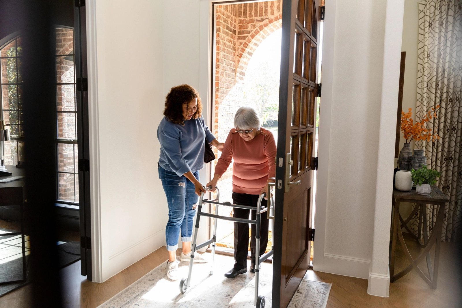 Caregiver helping a senior woman enter her home