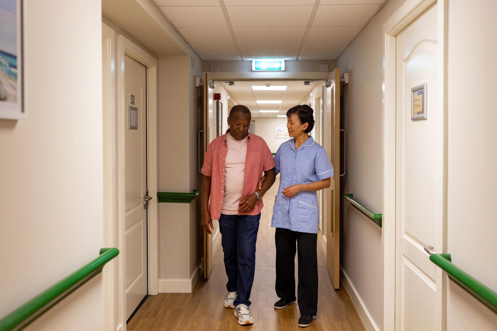 Care worker supporting an elderly resident indoors